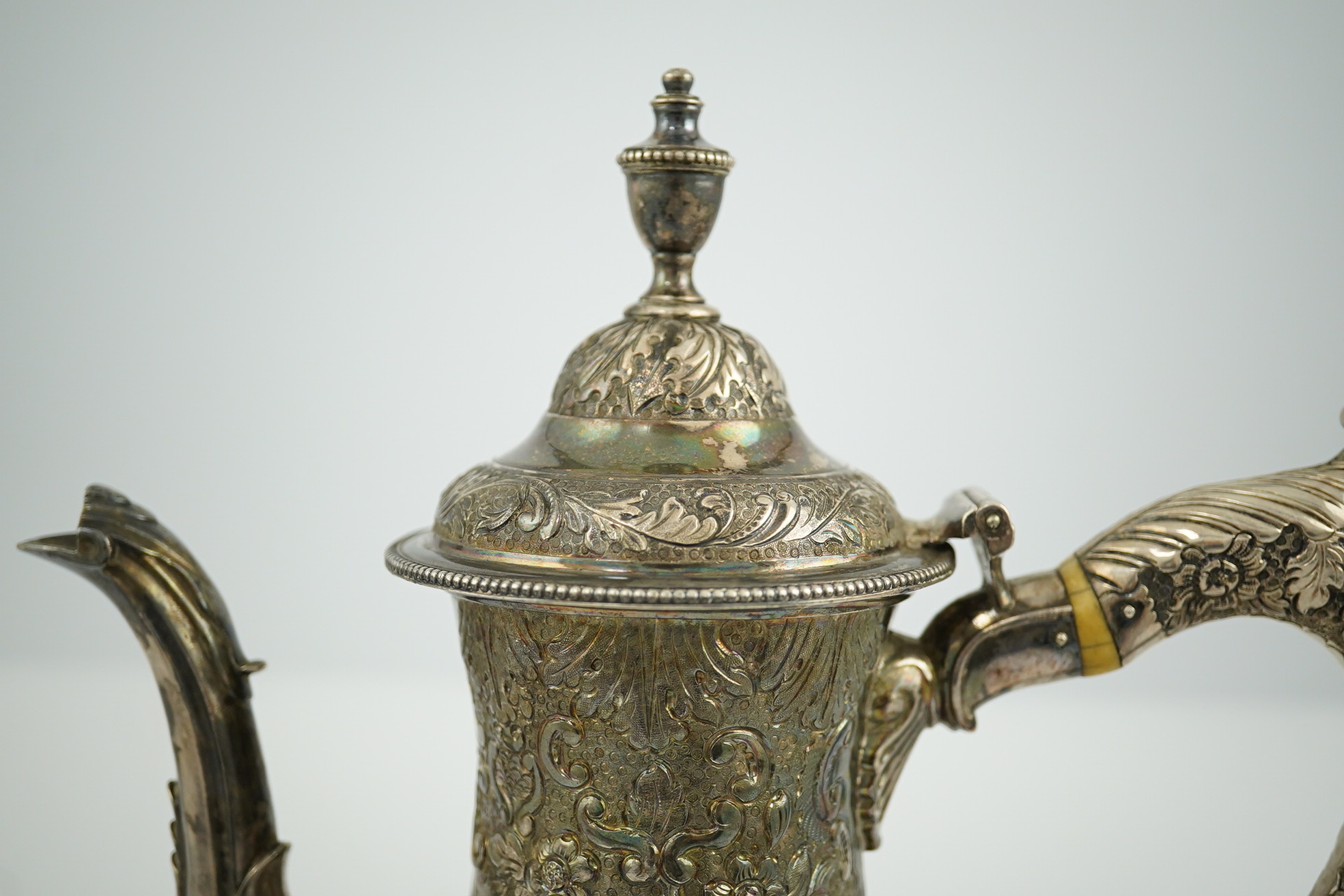 A George III silver pedestal coffee pot, with later embossed decoration